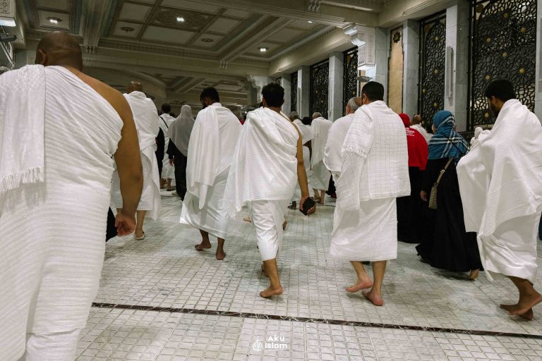Jemaah berpakaian ihram berjalan di Masjidil Haram