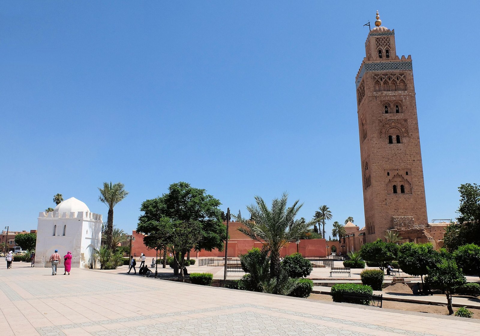 Koubba Lalla Zohra berwarna putih dan Menara Koutoubia di dataran sebelah masjid