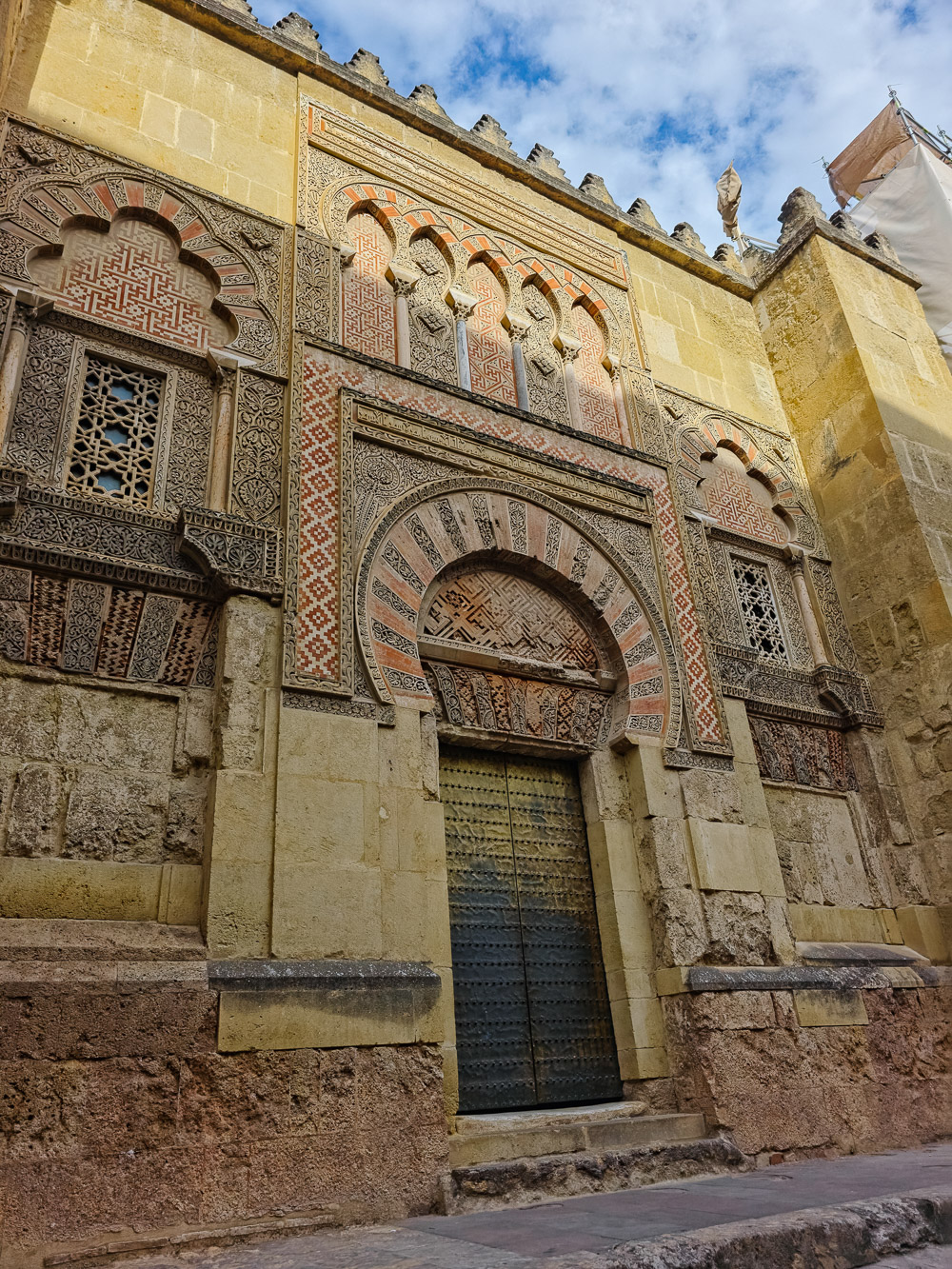 Fasad Masjid Agung Cordoba dengan ukiran geometri dan lengkungan warisan seni bina Andalusia.