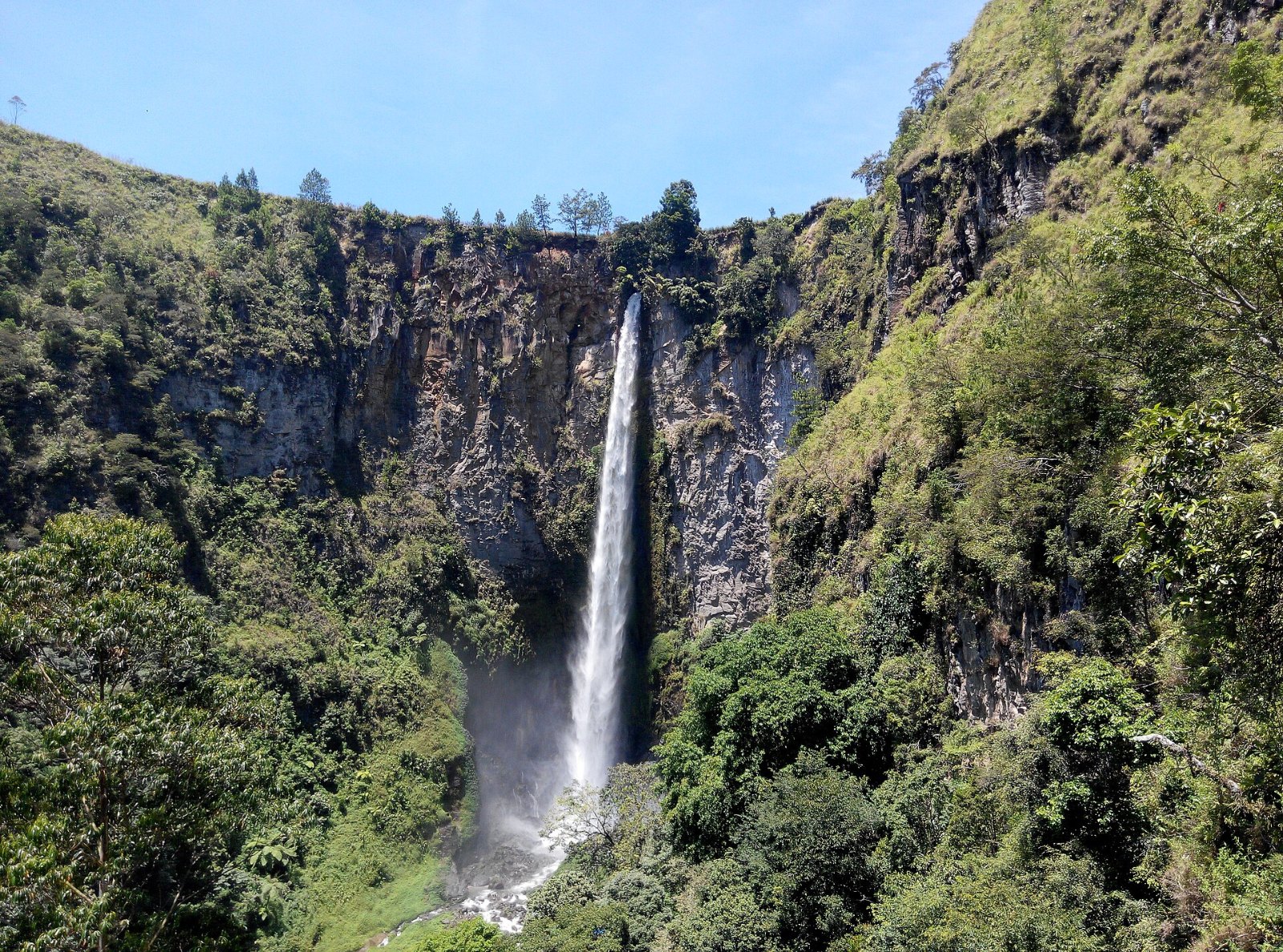 Air Terjun Sipiso-piso jatuh dari tebing hijau