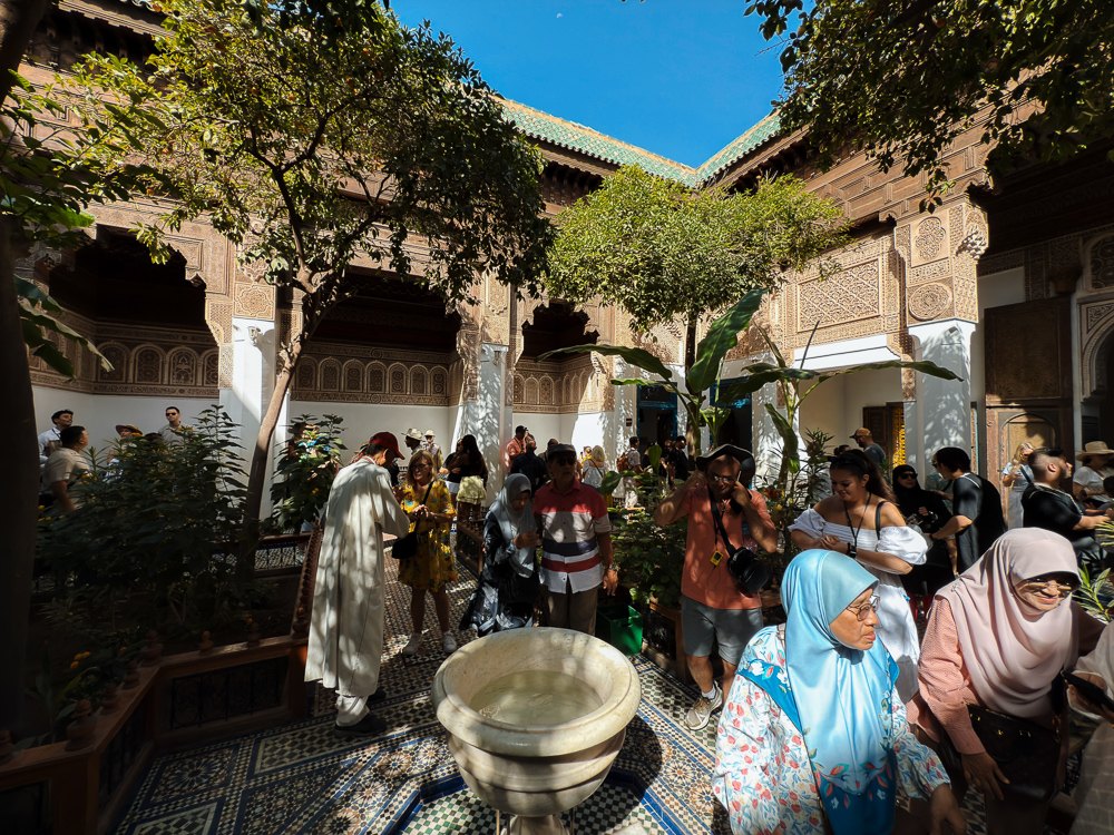 Taman riad yang teduh dengan pokok dan laluan berjubin di dalam istana