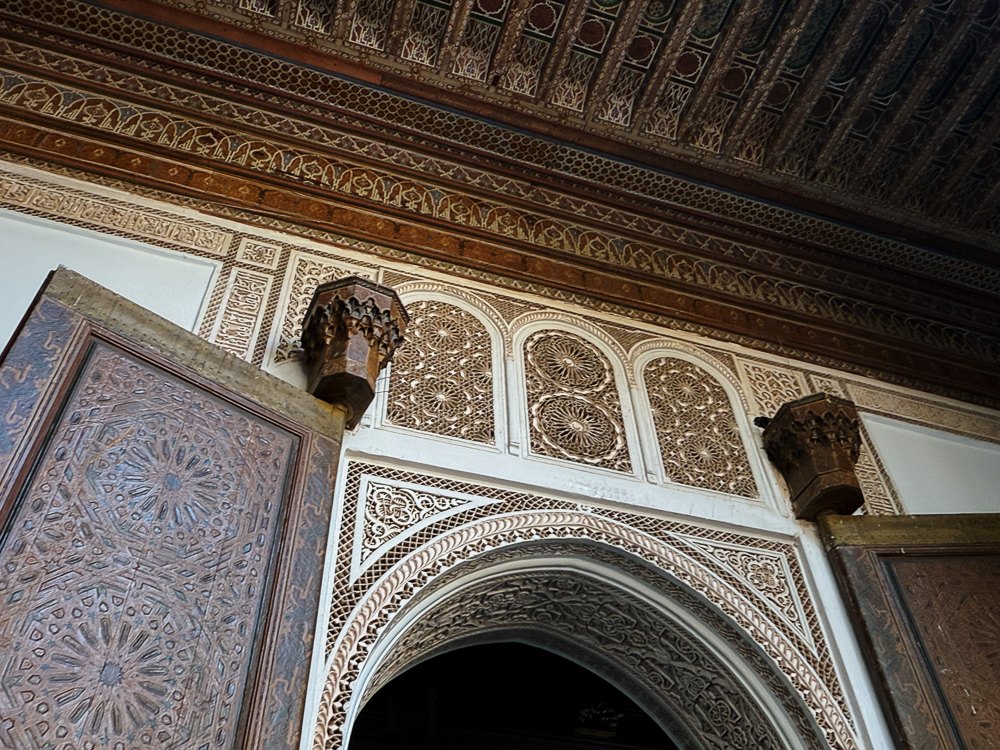 Ukiran plaster dan kayu cedar di atas lengkungan pintu istana