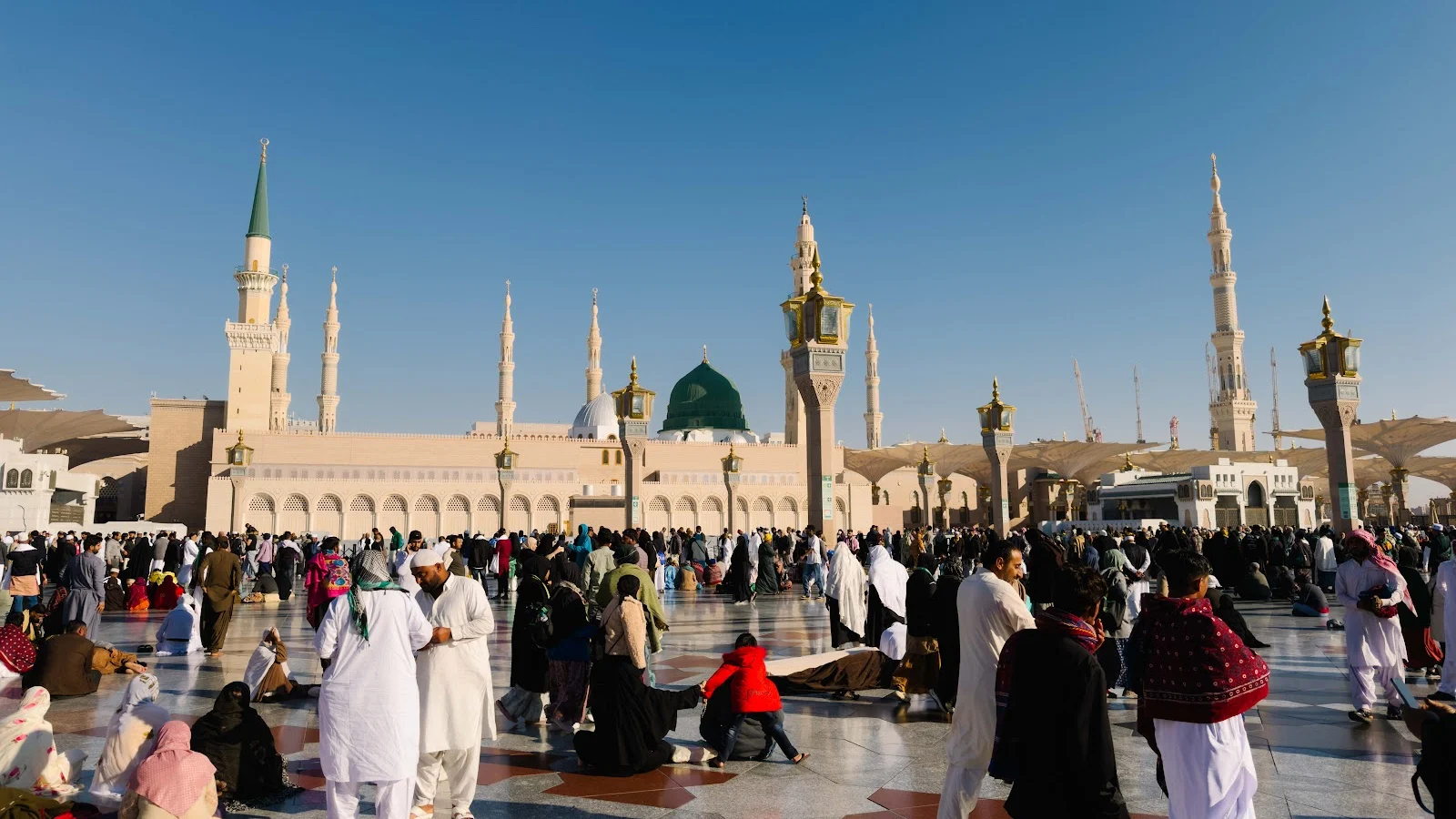 Halaman Masjid Nabawi dengan Kubah Hijau dan menara di kejauhan