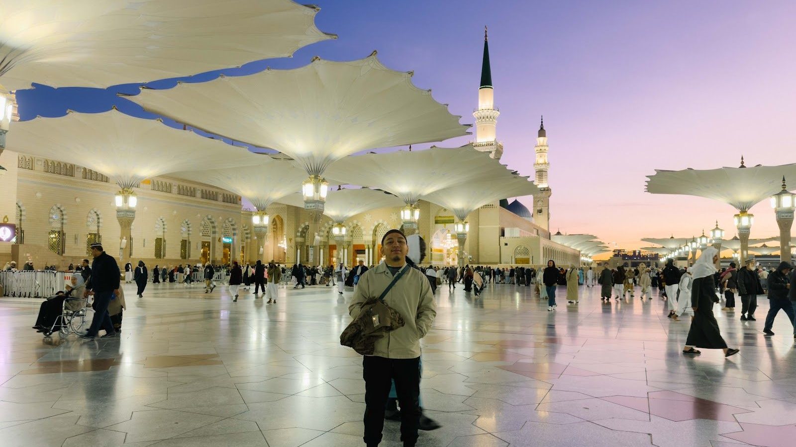 Dataran Masjid Nabawi pada waktu senja dengan payung gergasi dan menara, Madinah