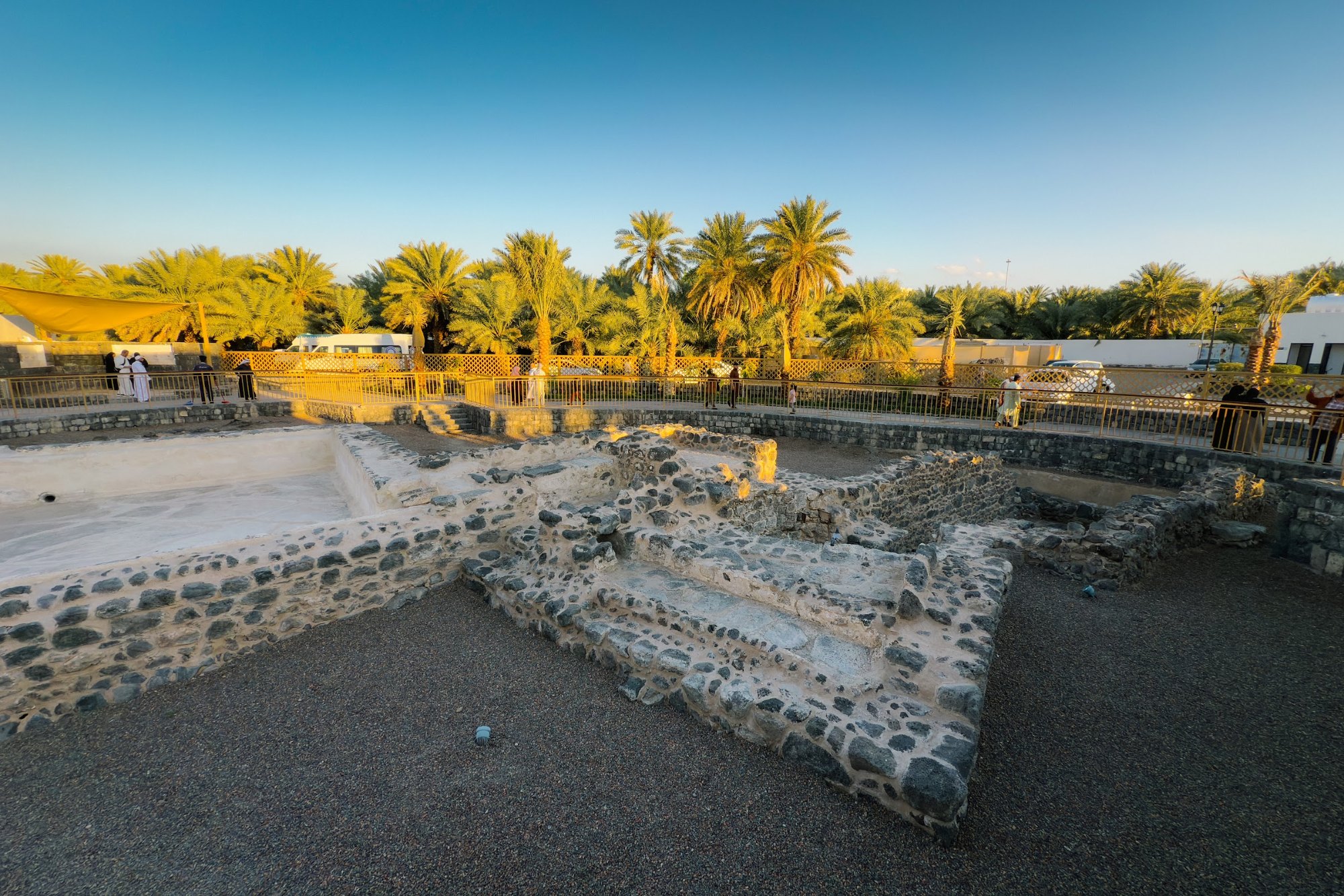 Tapak binaan batu basalt lama dikelilingi kebun kurma di kawasan warisan selatan Masjid Quba, Madinah