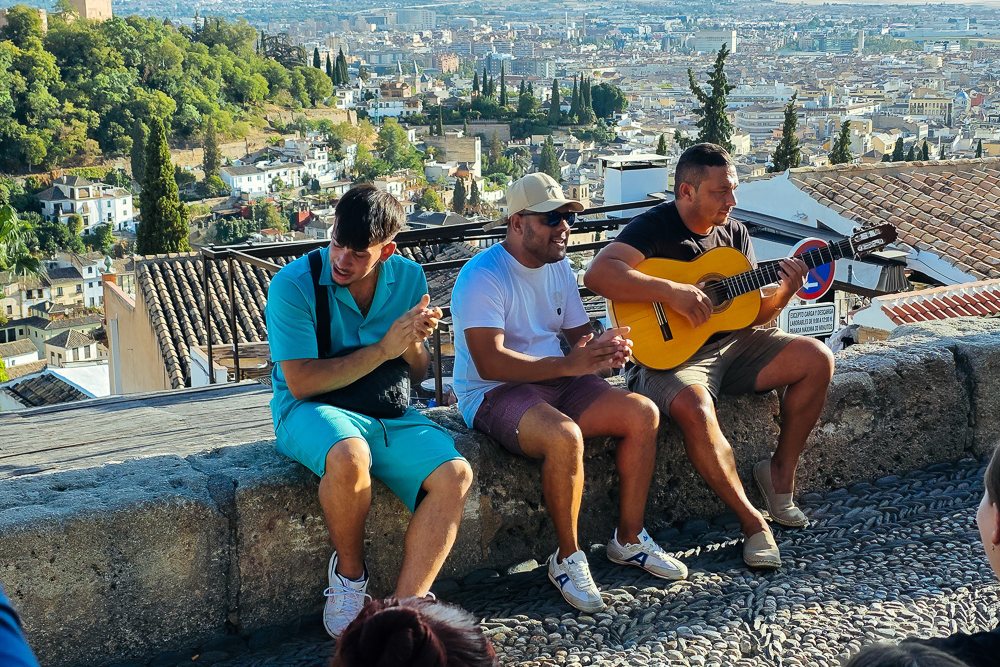 Pemuzik jalanan di Mirador San Nicolás dengan pemandangan kota Granada