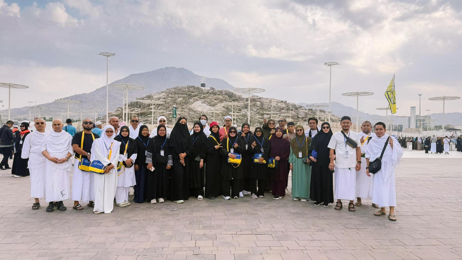 Rombongan jemaah MK Haramain bersama kru AkuIslam di Padang Arafah dengan Jabal Rahmah di belakang