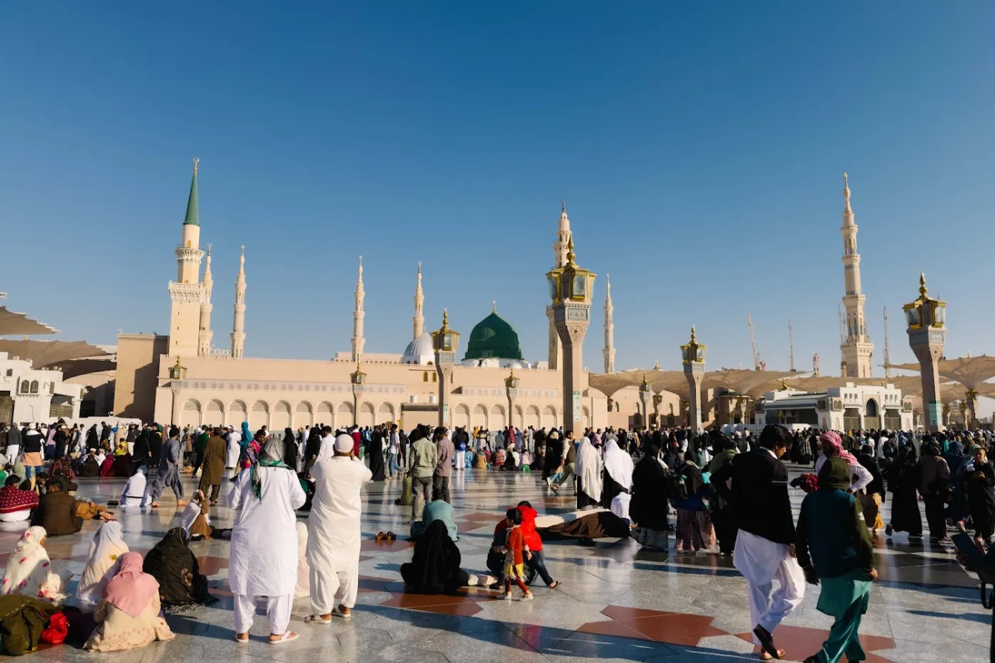 Jemaah berjalan di halaman Masjid Nabawi pada waktu pagi