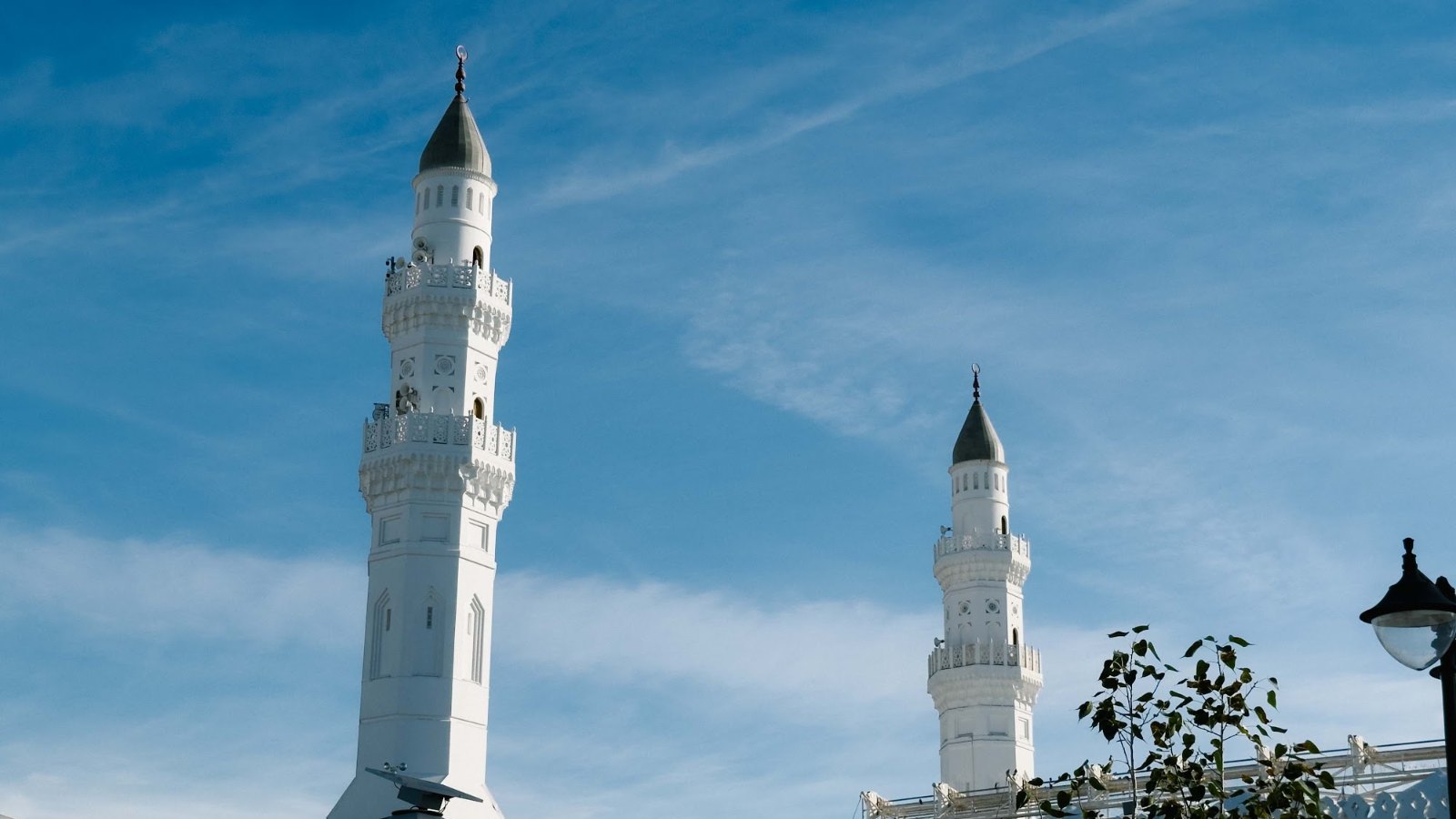 Dua menara putih Masjid Quba di Madinah di bawah langit biru