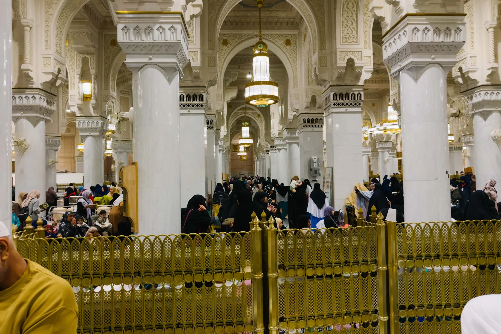 Tiang dan lengkungan serambi di dalam Masjidil Haram dengan jemaah yang sedang beribadah
