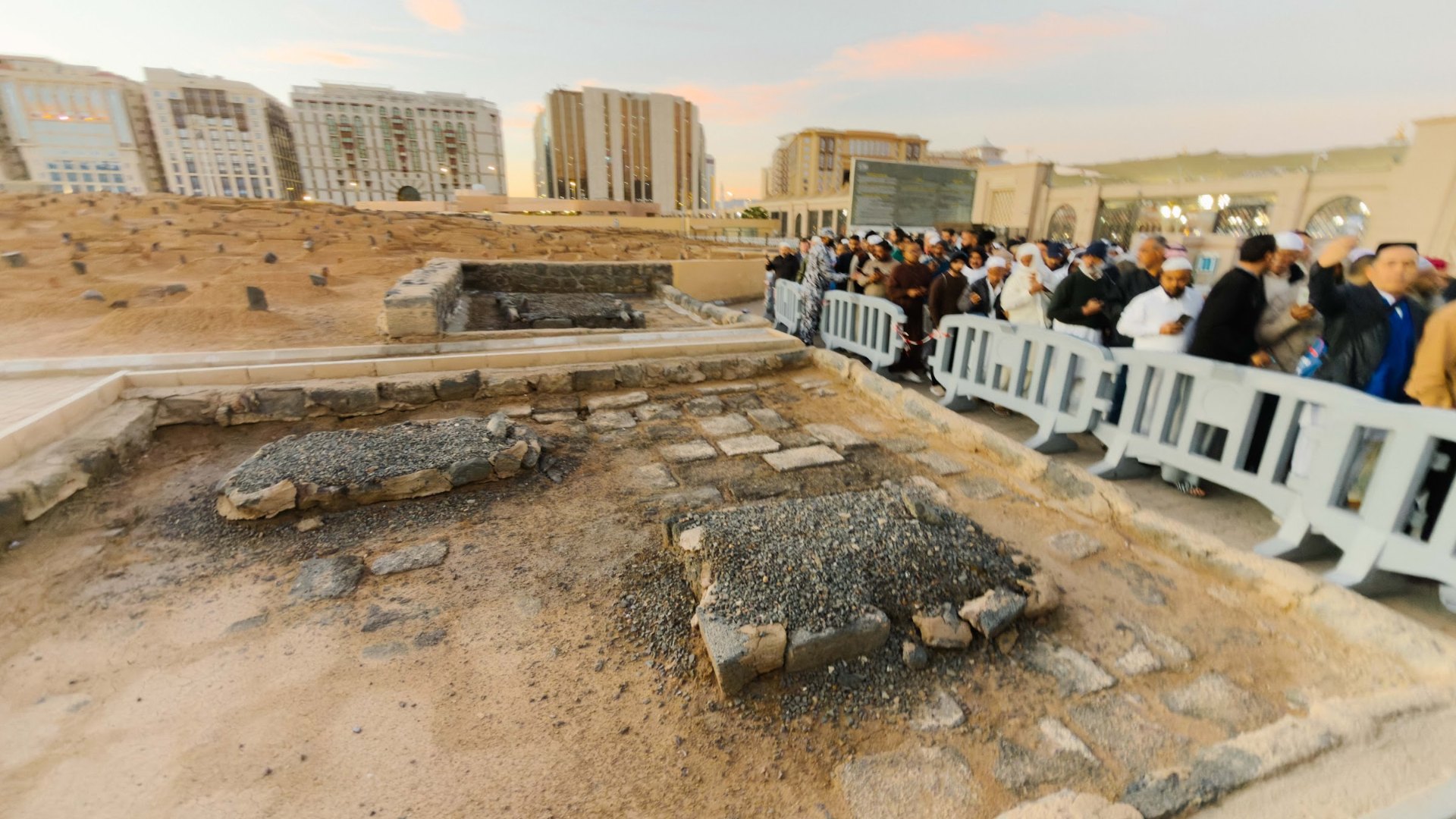 Jemaah lelaki berdiri di tepi laluan berpagar ketika menziarahi Perkuburan Baqi selepas Subuh