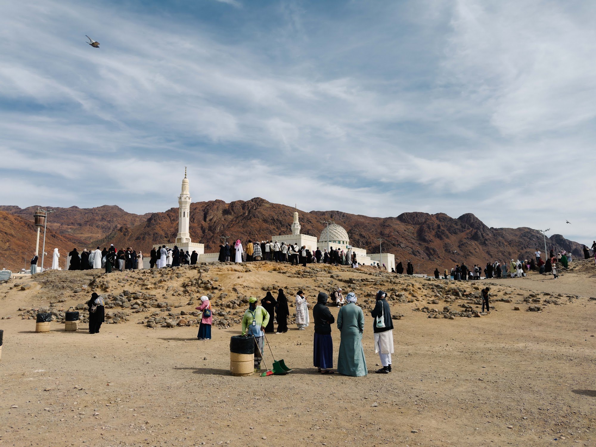 Jemaah di atas Jabal Rumat, bukit pemanah Perang Uhud, dengan Masjid Sayyid al-Shuhada dan Jabal Uhud di hadapan