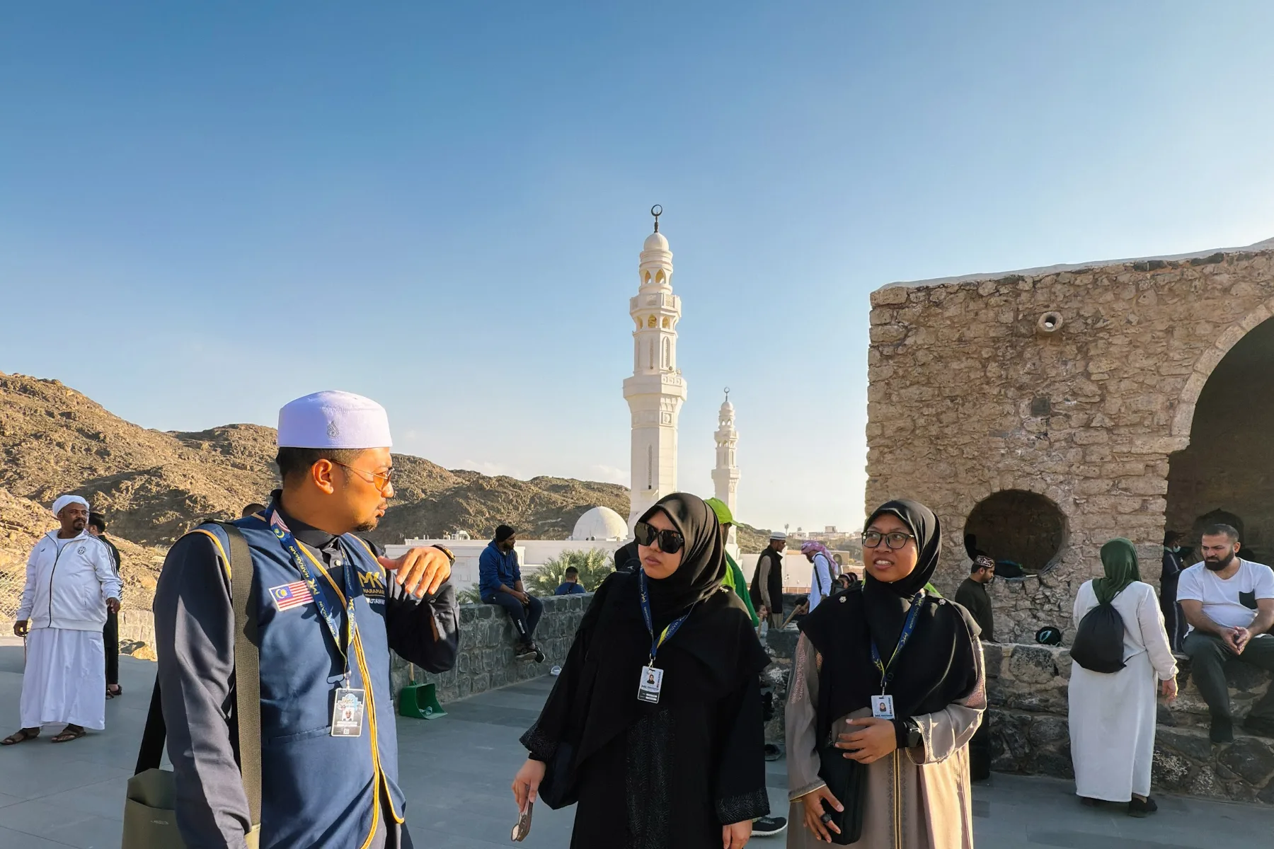 Mutawwif memberi penerangan sirah kepada jemaah umrah dengan rabung Jabal Sila’ di belakang
