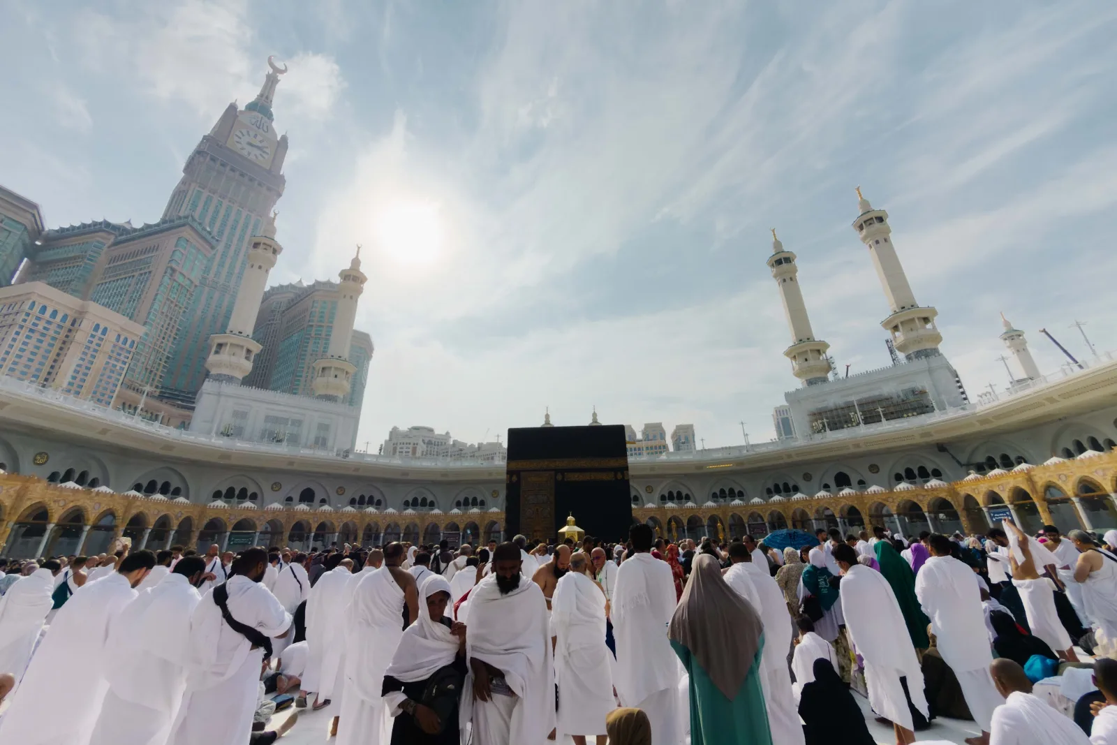 Jemaah berihram tiba di mataf dengan Kaabah dan Menara Jam di hadapan