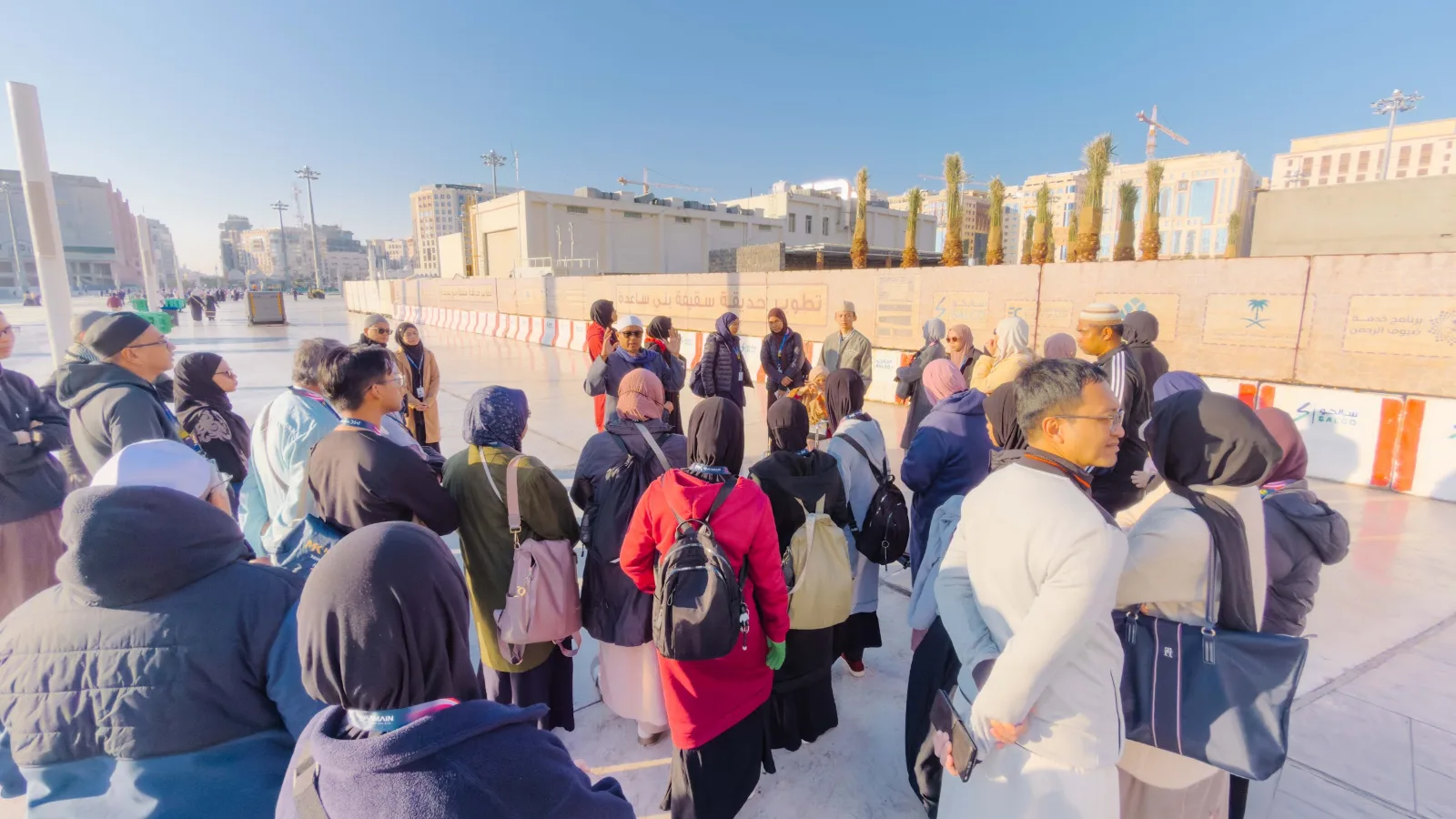 Rombongan jemaah berjaket pada pagi yang sejuk di dataran Masjid Nabawi