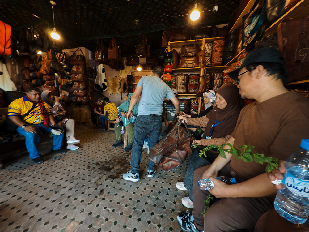 Peserta memegang daun pudina di kedai kulit Chouara Tannery Fes