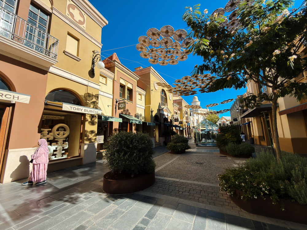 Lorong butik berwarna dengan hiasan tergantung di Las Rozas Village, Madrid