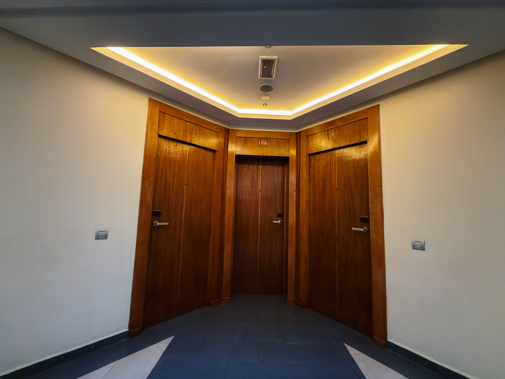 Lorong bilik dengan pintu kayu dan lampu siling