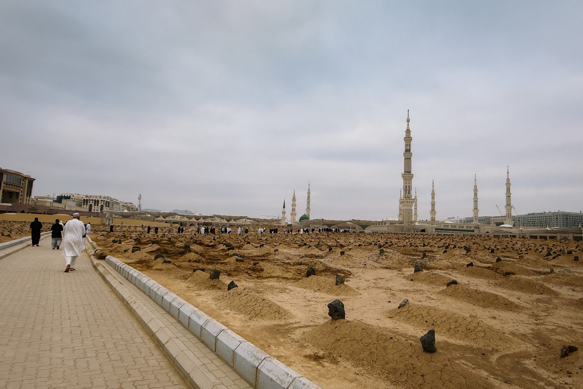 Laluan pejalan kaki di Makam Baqi dengan menara Masjid Nabawi di kejauhan