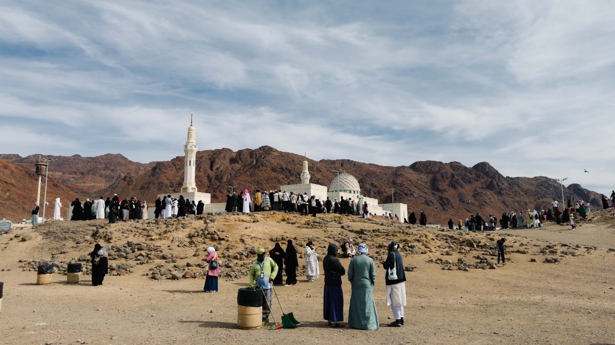Jemaah di kaki Bukit Rumat dengan menara Masjid Sayyid al-Syuhada dan Jabal Uhud di kejauhan