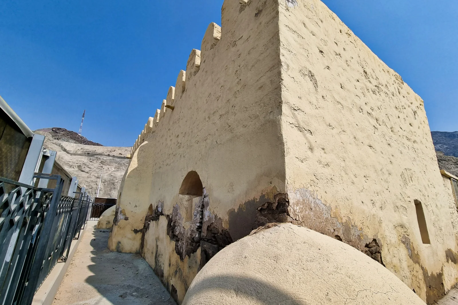 Dinding luar Masjid al-Bai‘ah berlatarkan langit biru di lereng Jabal Thabir