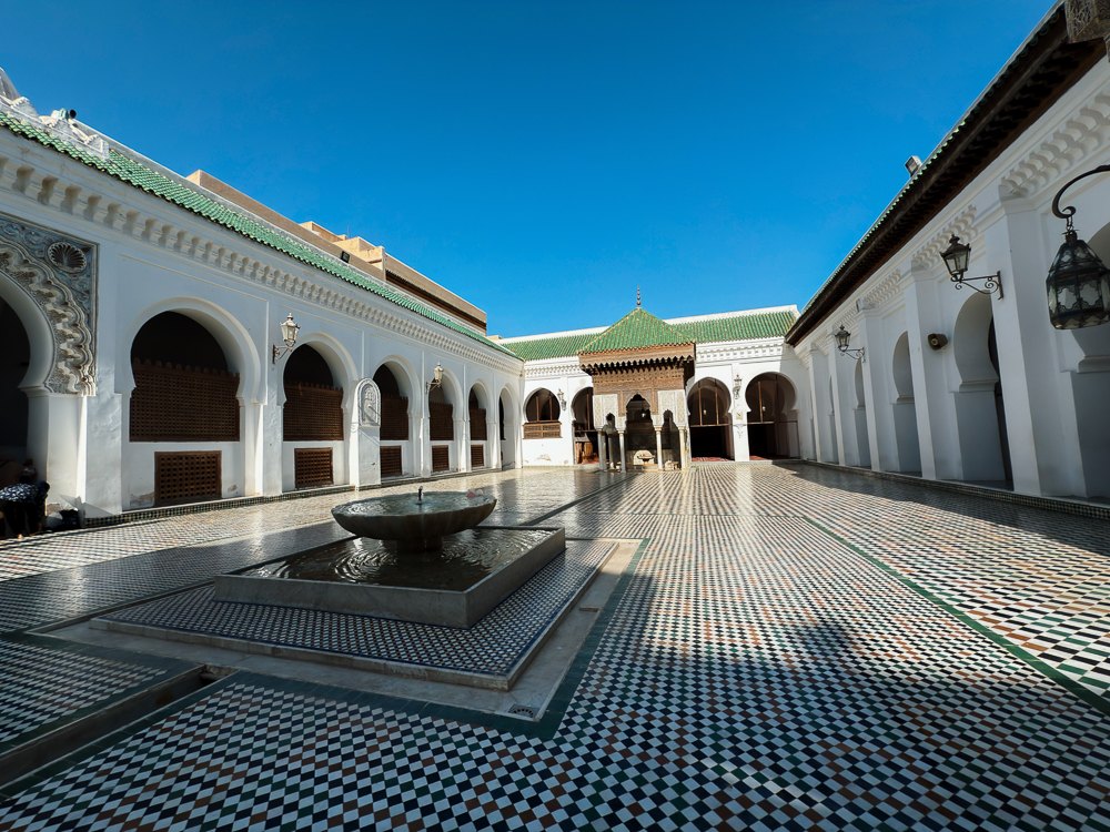 Halaman Masjid al-Qarawiyyin dengan lantai zellige dan pancutan air di tengah