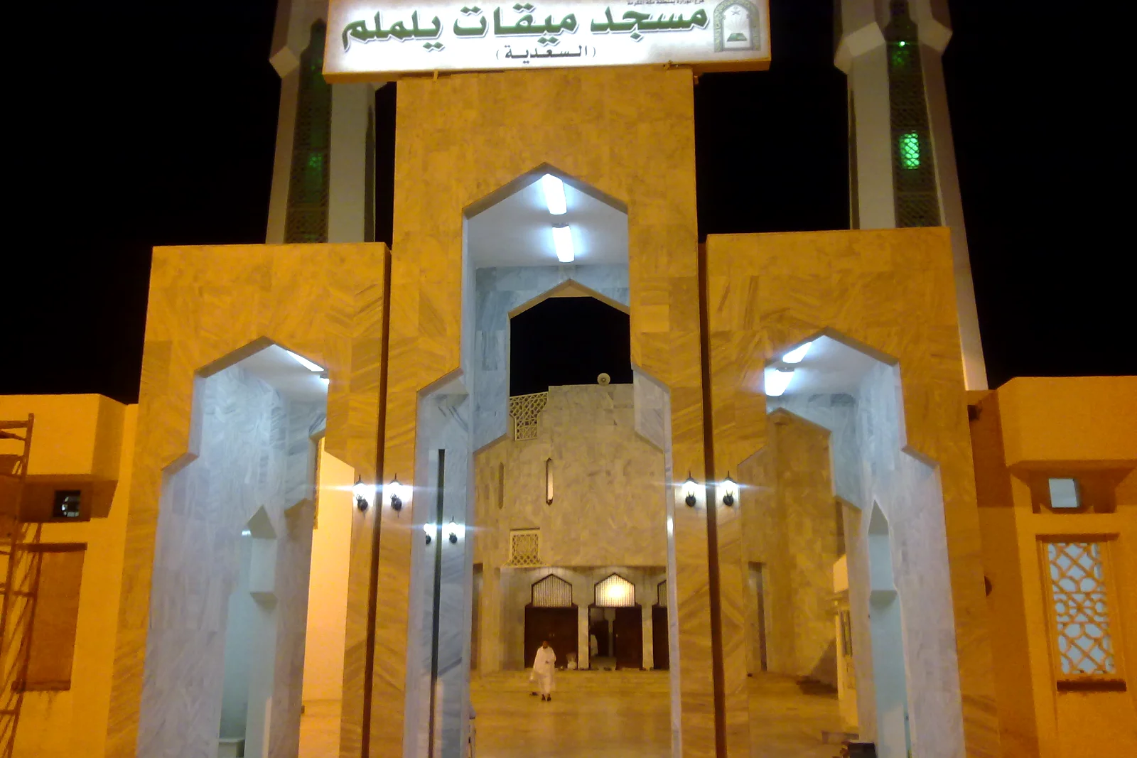 Pintu masuk Masjid Miqat Yalamlam atau Masjid As-Sa’diyah pada waktu malam dengan papan nama Arab