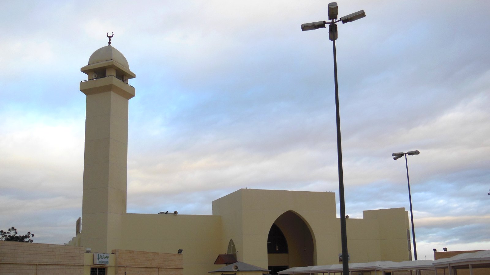 Menara dan pintu gerbang Masjid Miqat As-Sail Al-Kabir dengan jemaah berihram