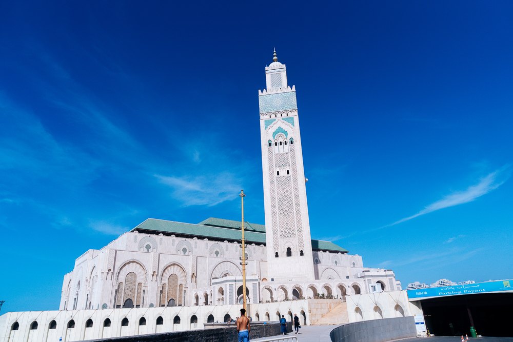 Fasad masjid dengan lengkungan berukir dan bumbung jubin hijau dari dataran