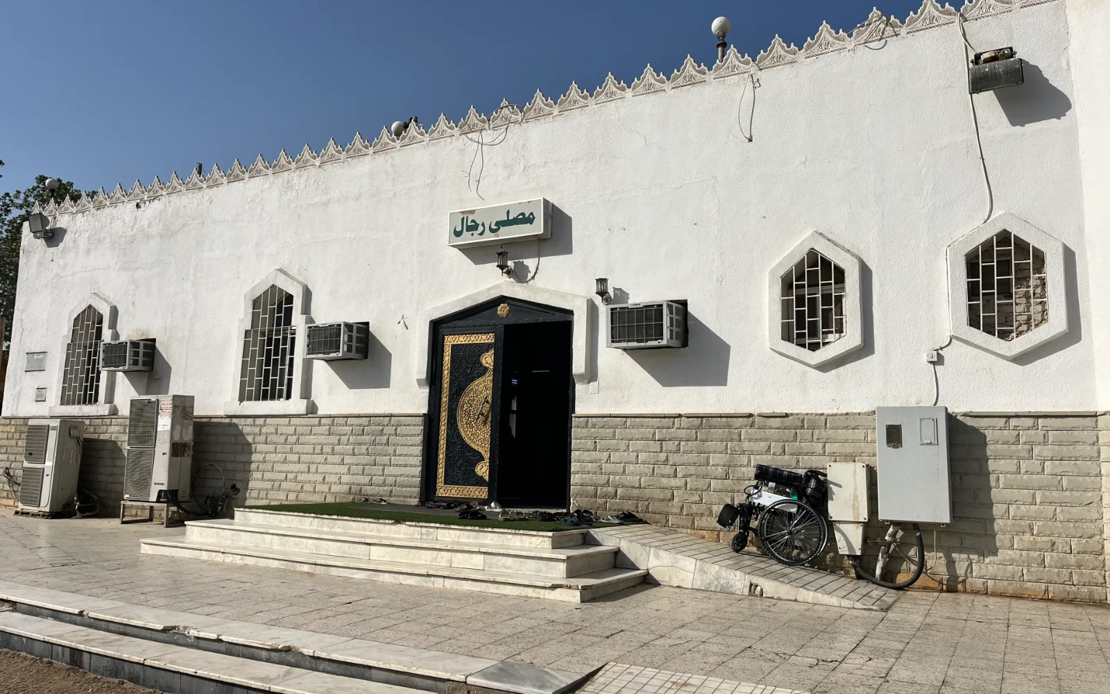 Pintu masuk utama Masjid Hudaibiyah yang berdinding putih