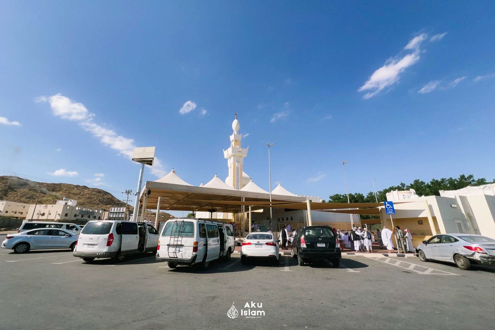 Menara putih Masjid Ji‘ranah dengan khemah teduhan dan kawasan parkir, Makkah