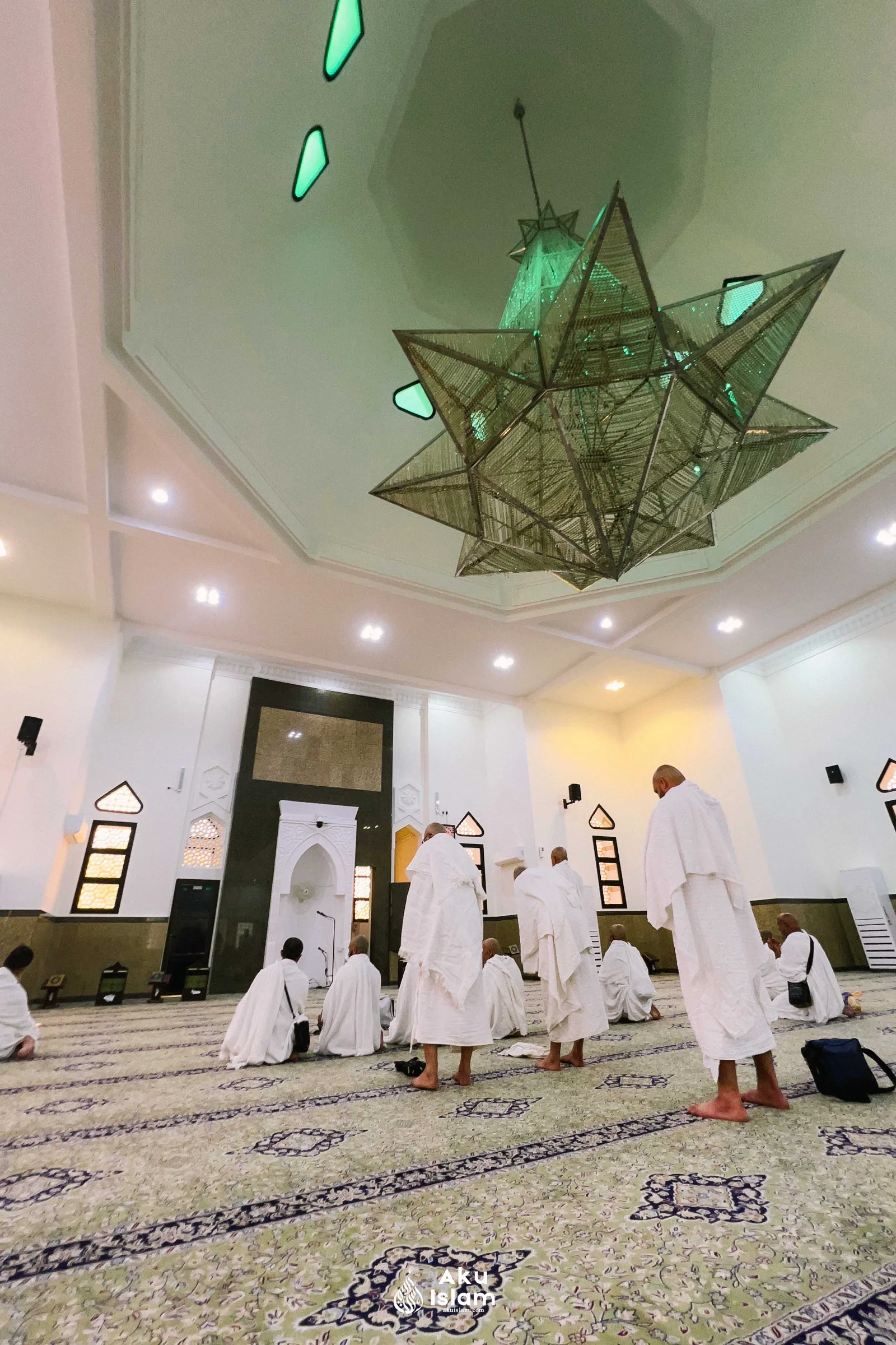 Jemaah berihram solat sunat di ruang solat Masjid Ji‘ranah yang berlampu gantung bintang