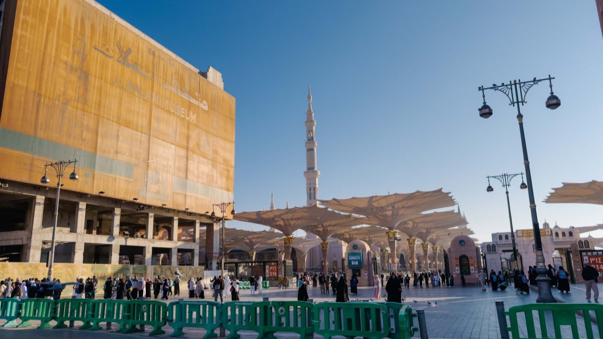 Jemaah berjalan di dataran Masjid Nabawi berhampiran payung teduhan