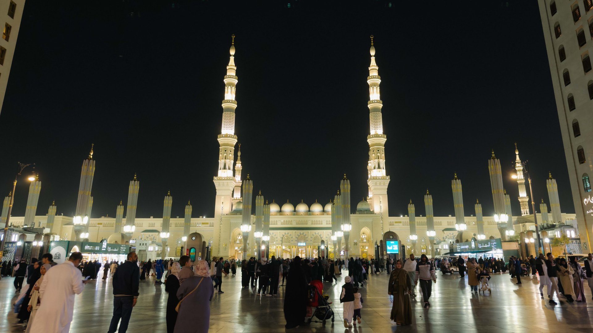 Dataran Masjid Nabawi pada waktu malam dengan menara dan payung gergasi yang bercahaya