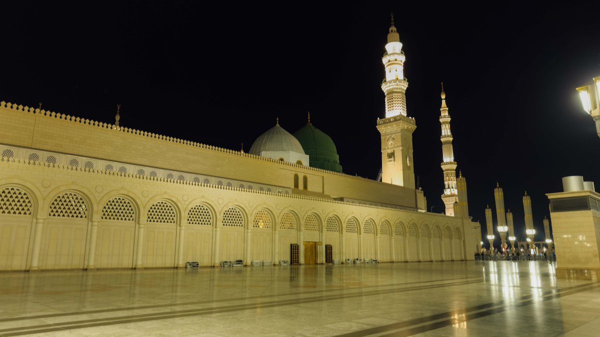 Masjid Nabawi pada waktu malam dengan Kubah Hijau dan menara yang bercahaya