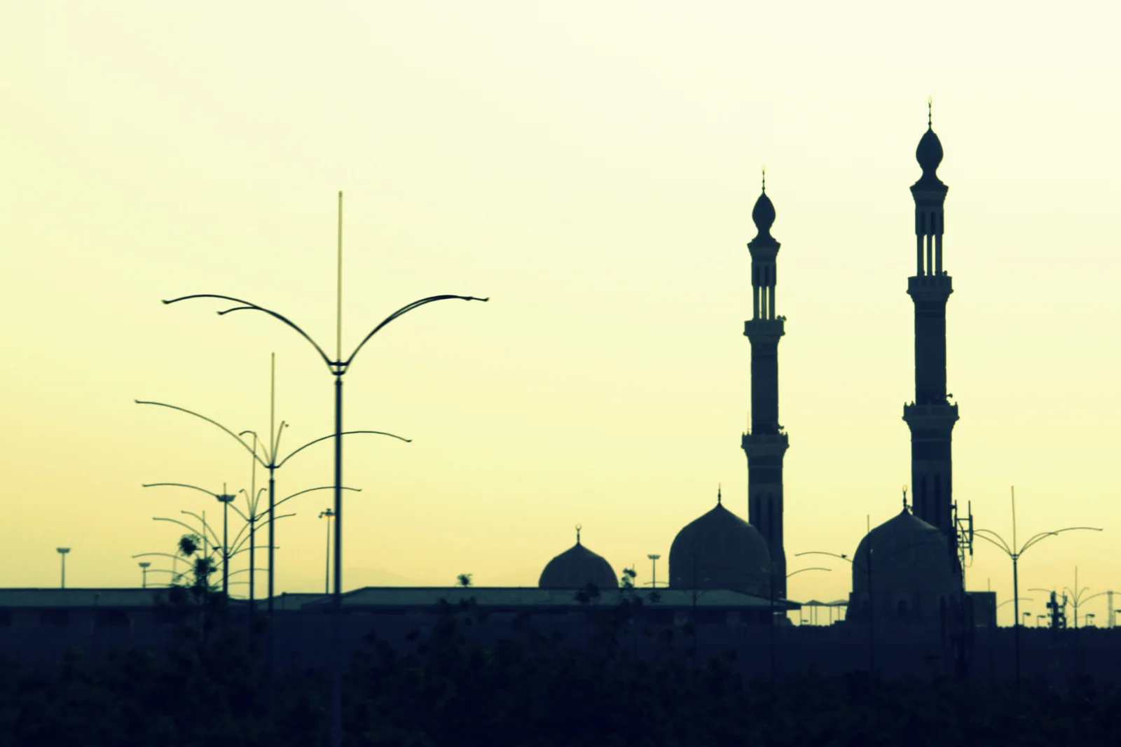 Siluet menara dan kubah Masjid Namirah ketika senja di Arafah