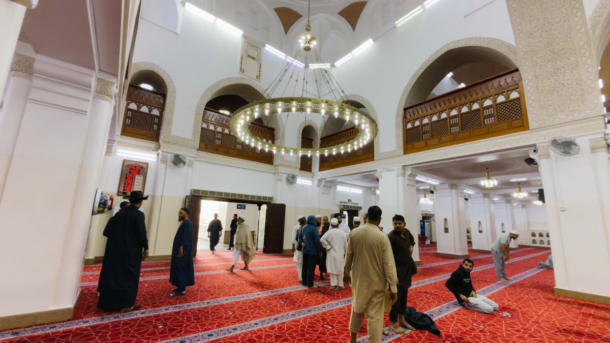 Ruang solat Masjid Qiblatain dengan lampu gantung bulat dan galeri kayu