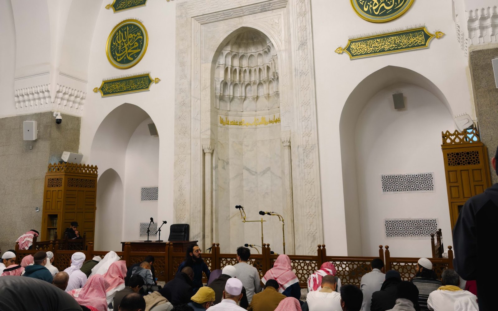 Mihrab Masjid Quba dengan kaligrafi hijau dan jemaah di ruang solat