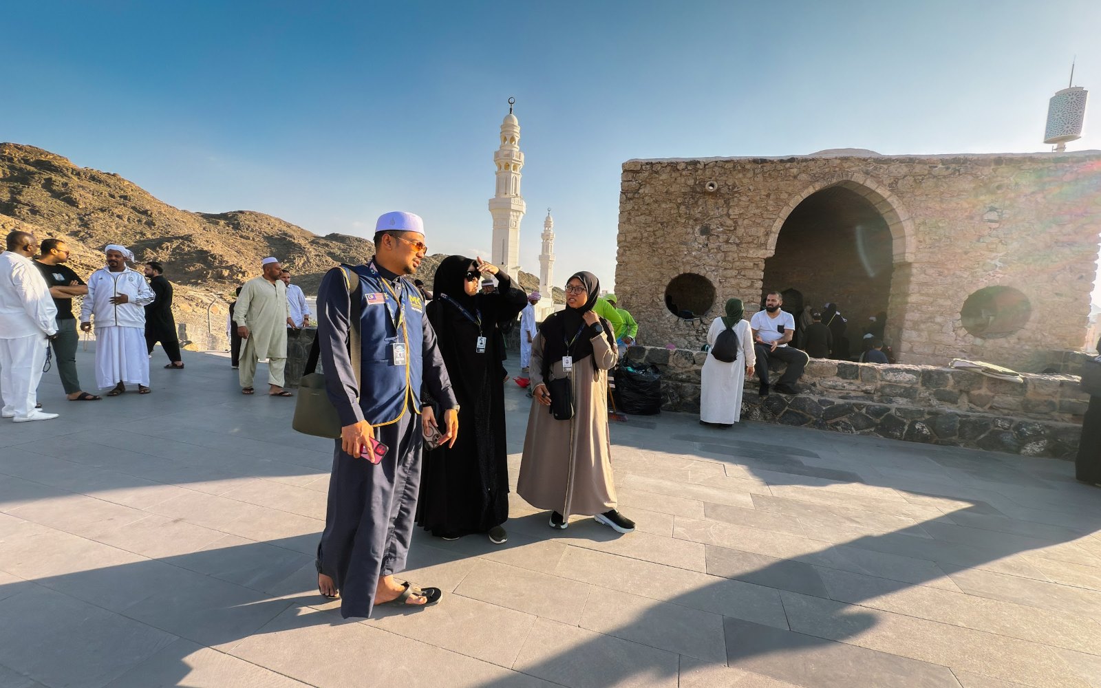 Jemaah umrah di atas bukit kecil kawasan Masjid Tujuh dengan menara Masjid Khandaq