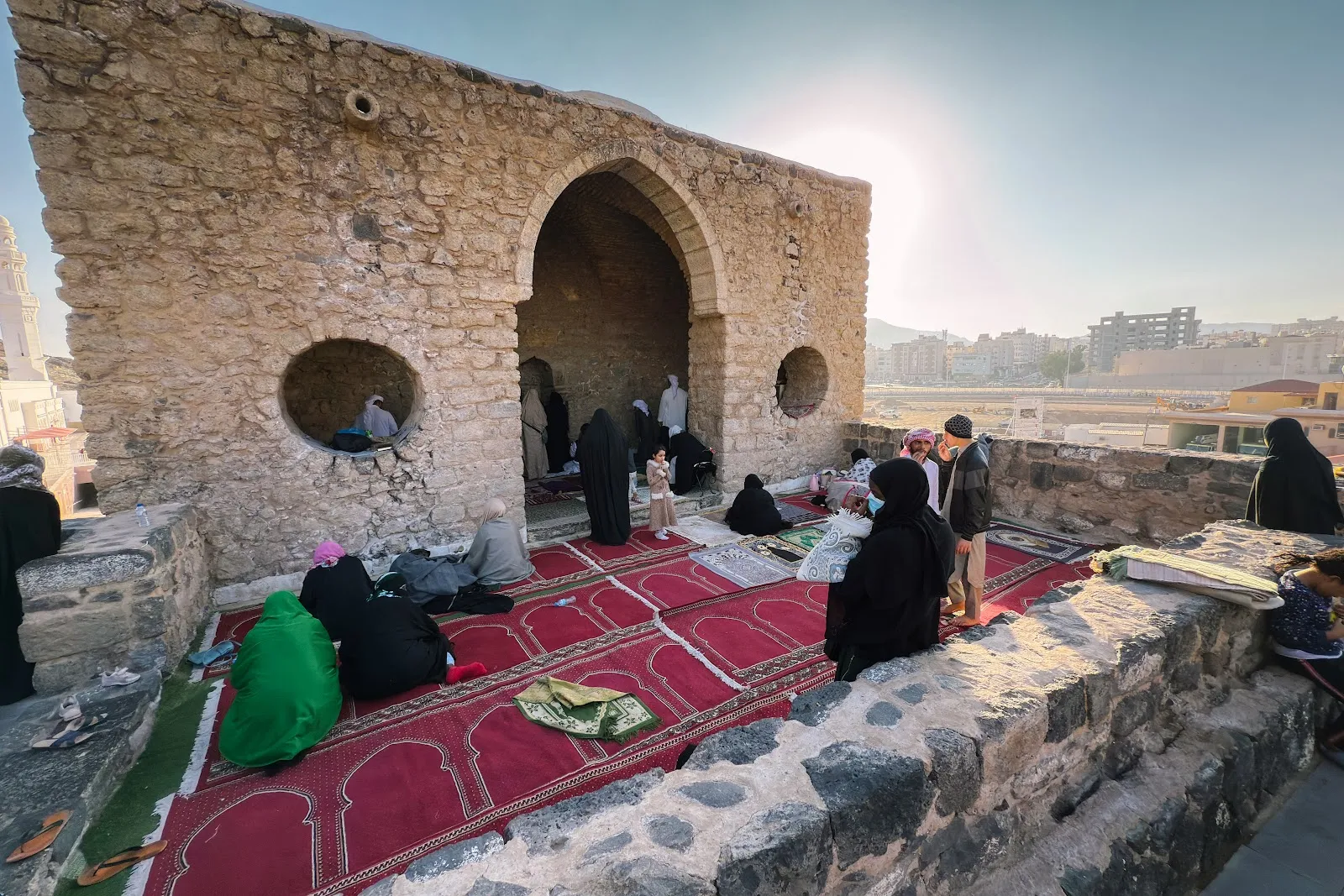 Jemaah duduk dan solat di atas permaidani di masjid batu kecil kawasan Masjid Tujuh