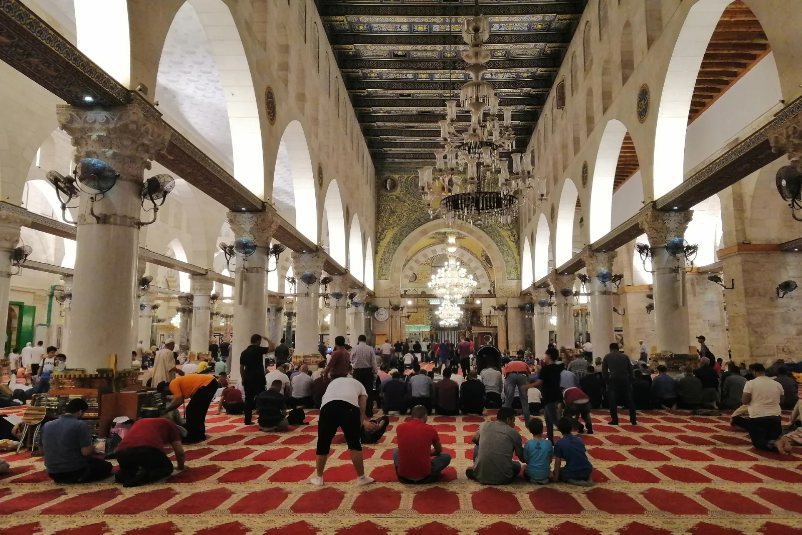 Ruang solat Masjid Al-Qibli dengan barisan tiang dan lampu gantung