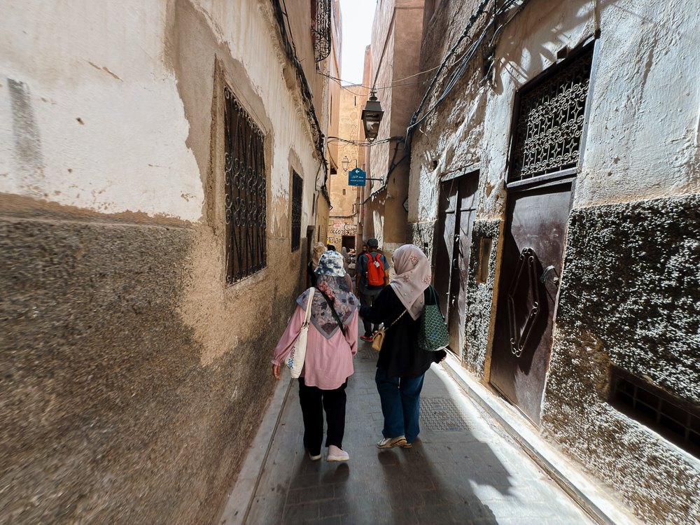Lorong sempit berdinding lama dan pintu kayu di Fes el-Bali