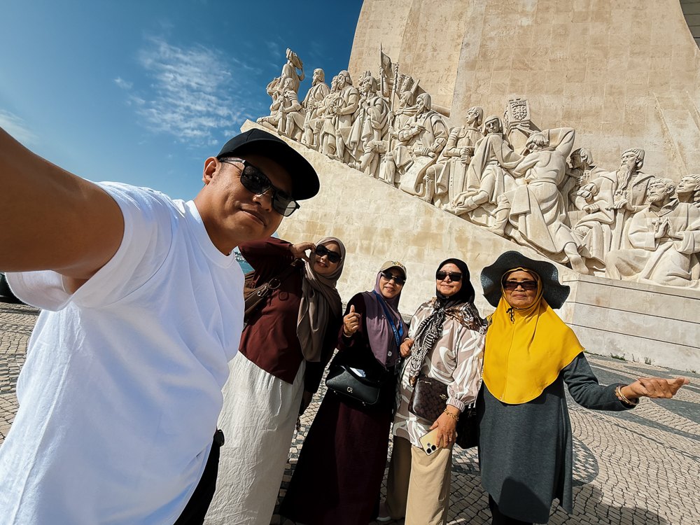 Rombongan pengembara Muslim bergambar di hadapan patung monumen