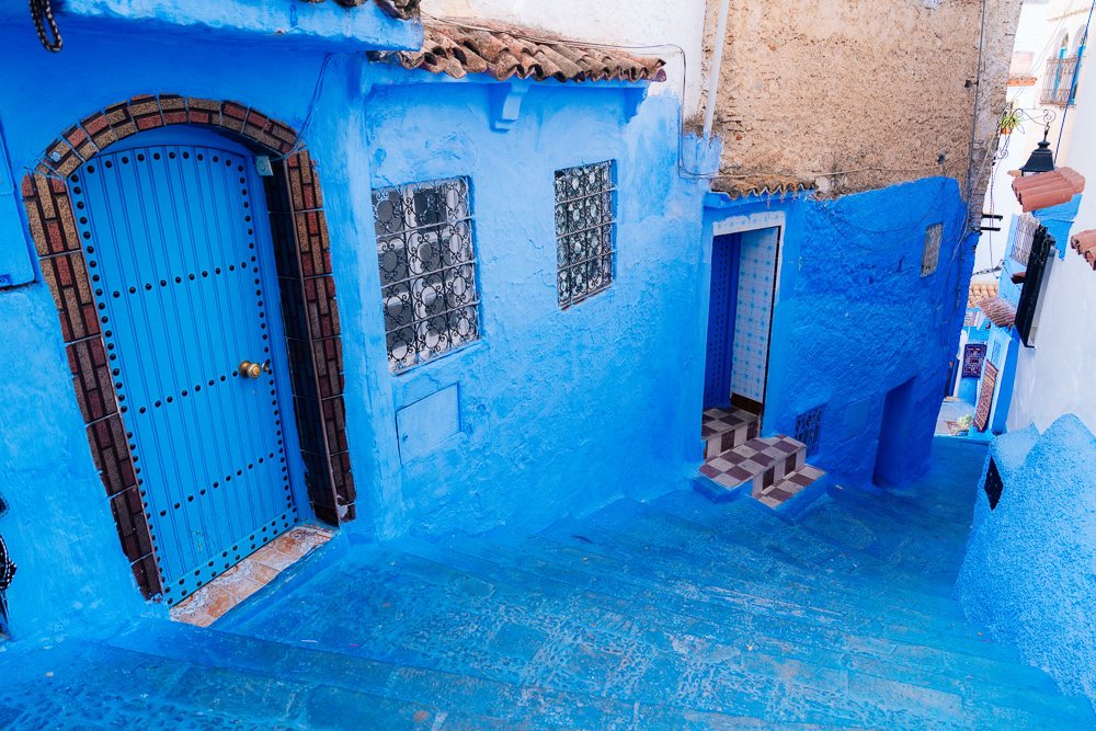 Panduan melawat Morocco, pintu kayu dan dinding biru di lorong Chefchaouen