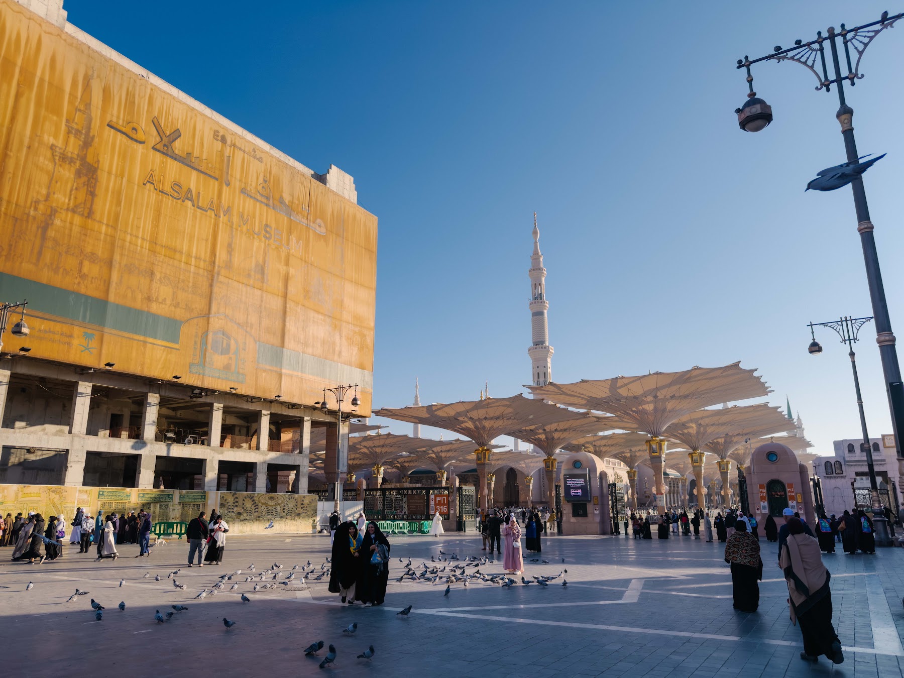 Halaman Masjid Nabawi pada waktu pagi dengan payung gergasi dan menara masjid