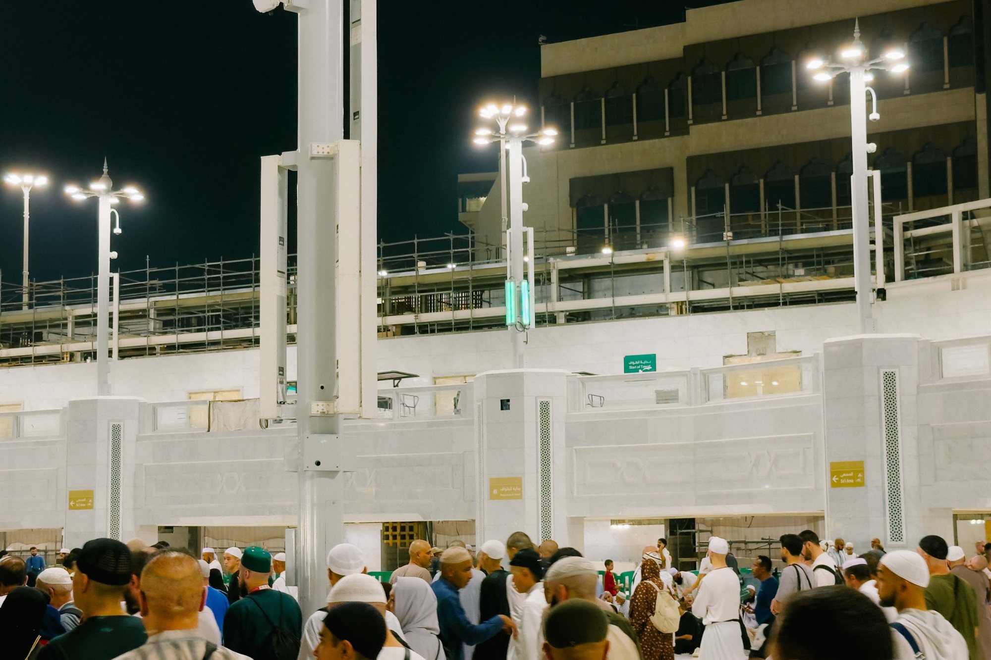 Menara Masjidil Haram diterangi lampu pada waktu malam dengan jemaah memenuhi perkarangan