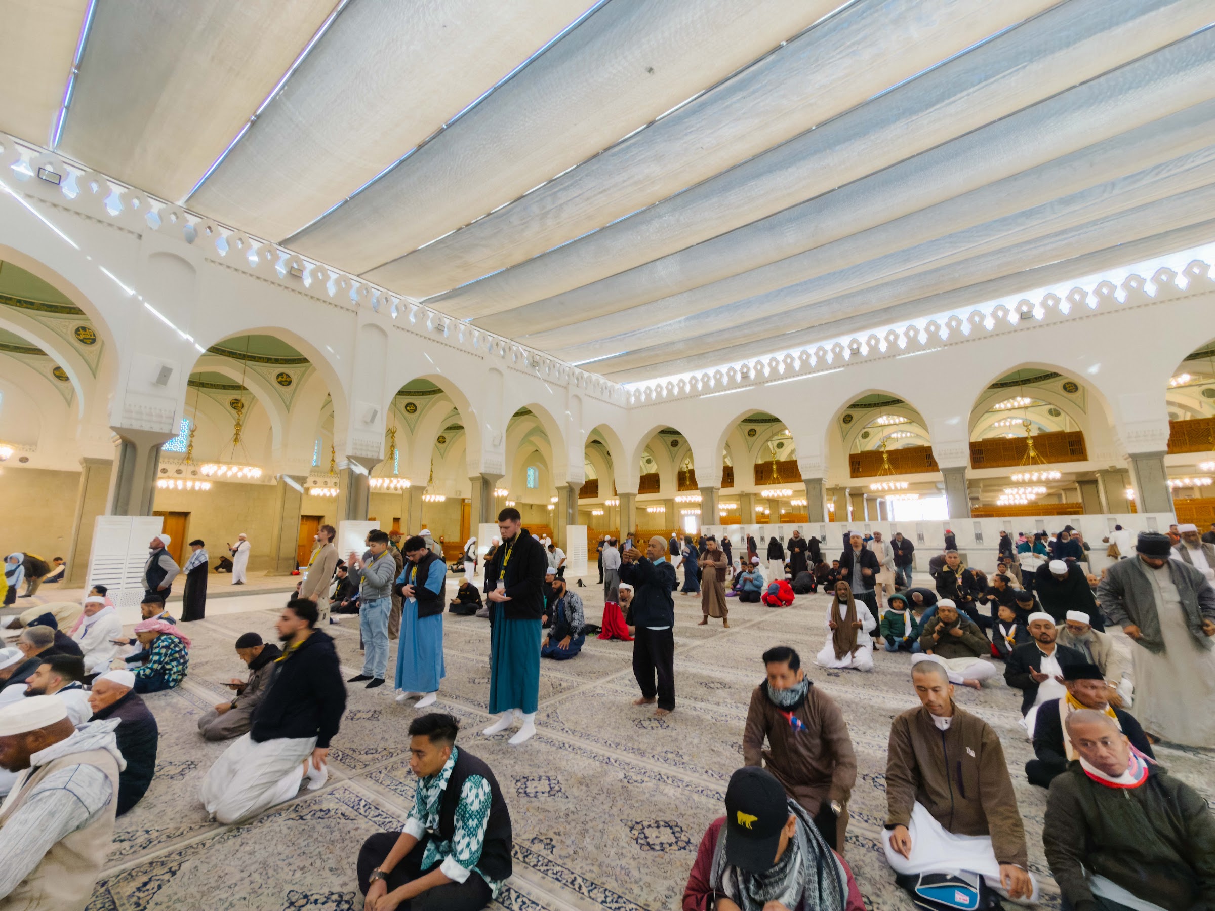 Jemaah duduk dan berzikir di dewan solat Masjid Quba yang dikelilingi lengkungan putih