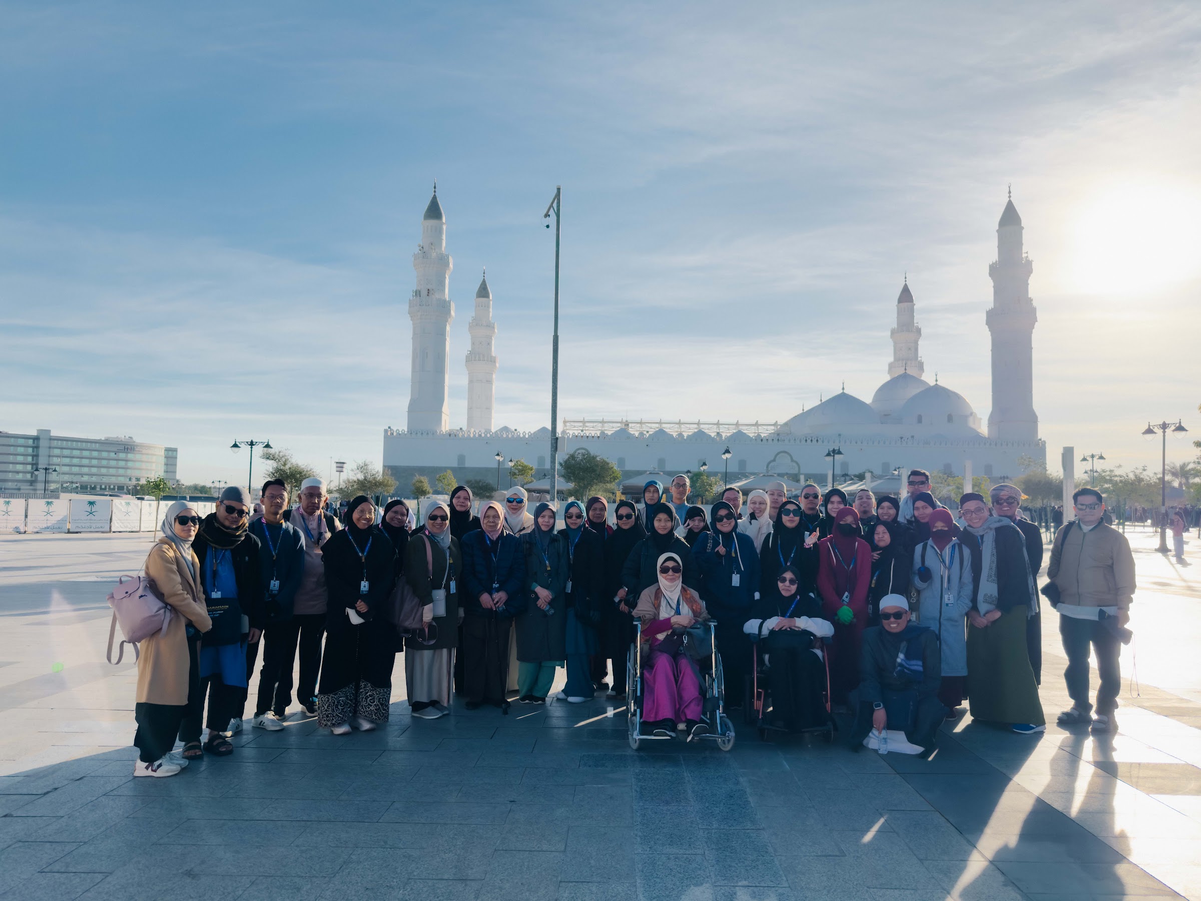 Rombongan jemaah umrah berkumpul di dataran Masjid Quba dengan menara masjid di belakang