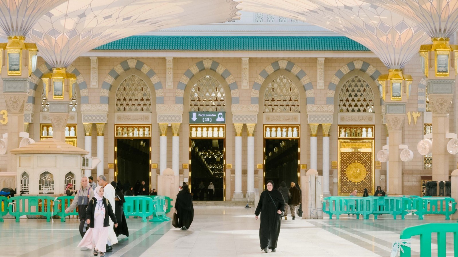 Jemaah melalui pintu 13 Masjid Nabawi di bawah payung gergasi pada waktu pagi
