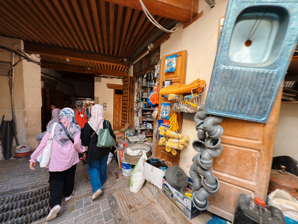 Peserta wanita berjalan di lorong medina Fes